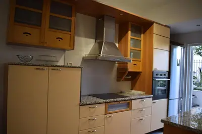 a kitchen with wooden cabinets and a stove at h2h Dafni #Family home near Athens, airport, ports with garden in Athens