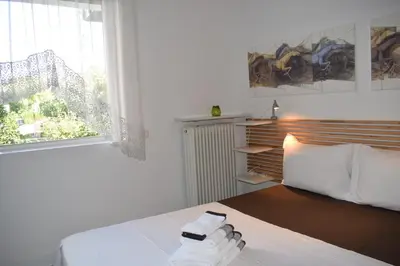 a bedroom with a bed and a window with towels on it at h2h Dafni #Family home near Athens, airport, ports with garden in Athens