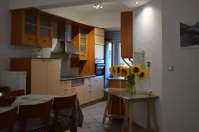 a kitchen with a table with a vase of flowers on it at h2h Dafni #Family home near Athens, airport, ports with garden in Athens