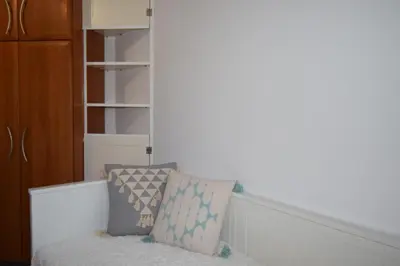 a couch with two pillows on it in a room at h2h Dafni #Family home near Athens, airport, ports with garden in Athens