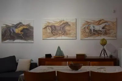 a living room with paintings of horses on the wall at h2h Dafni #Family home near Athens, airport, ports with garden in Athens