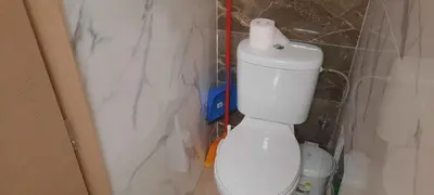 a bathroom with a toilet with a roll of toilet paper on the tank at Livia's Room To Ampelokipi metro Airport line in Athens