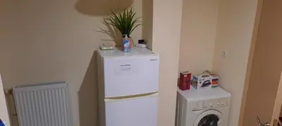 a kitchen with a refrigerator and a washing machine at Livia's Room To Ampelokipi metro Airport line in Athens