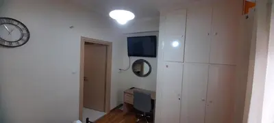a room with a desk and a clock on a wall at Livia's Room To Ampelokipi metro Airport line in Athens