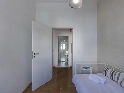 a white room with a bed and a hallway at Beautiful Athenian apartment next to the center in Athens