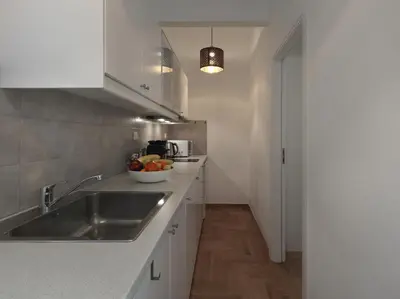 a kitchen with a sink and a bowl of fruit on the counter at Beautiful Athenian apartment next to the center in Athens