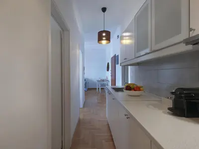 a kitchen with white cabinets and a bowl of fruit on the counter at Beautiful Athenian apartment next to the center in Athens