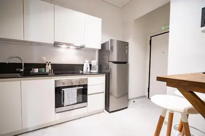 a kitchen with white cabinets and a stainless steel refrigerator at Athens-center 1 bedroom 2 persons apt by MPS in Athens