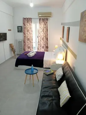 a living room with a couch and a bed at Cozy spot apt next to metro station . in Athens
