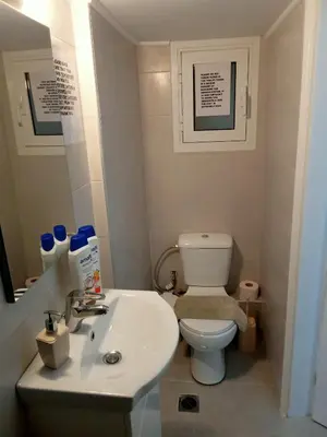 a bathroom with a white toilet and a sink at Cozy spot apt next to metro station . in Athens