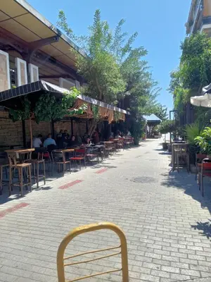 a chair in front of a building with tables and chairs at Cozy spot apt next to metro station . in Athens