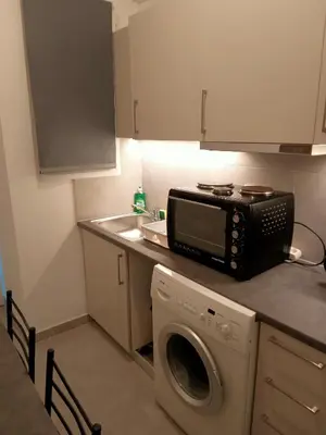 a kitchen with a microwave and a washing machine at Cozy spot apt next to metro station . in Athens
