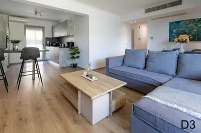 a living room with a blue couch and a table at Sea view apartments in Alimos region in Athens