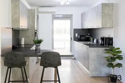 a kitchen with a counter and two bar stools at Sea view apartments in Alimos region in Athens