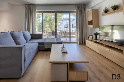 a living room with a blue couch and a tv at Sea view apartments in Alimos region in Athens