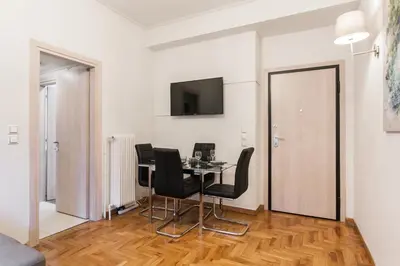 a dining room with a table and black chairs at Plaka's Arch Studio in Athens