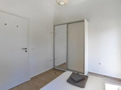 a bedroom with white walls and a mirror at Beautiful Athenian apartment with terrace in Athens