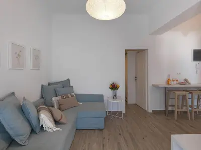 a living room with a blue couch and a table at Beautiful Athenian apartment with terrace in Athens