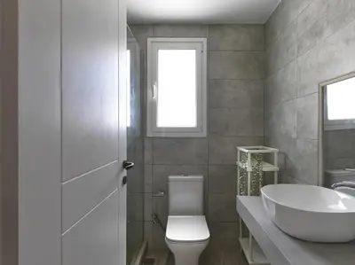 a bathroom with a white toilet and a sink at Beautiful Athenian apartment with terrace in Athens