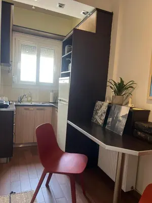 a kitchen with a table and a red chair at Athens Taratsaki in Athens