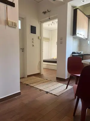 an open room with a kitchen and a living room at Athens Taratsaki in Athens