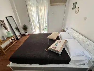 a bedroom with a large bed with a black blanket at Athens Taratsaki in Athens