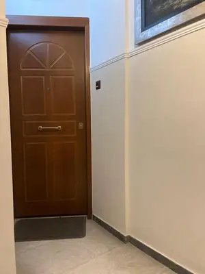 a brown door in a room with a wall at Athens Taratsaki in Athens