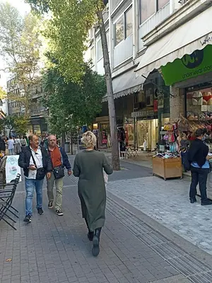 a group of people walking down a street at Lovely apartment in the center of Athens. in Athens