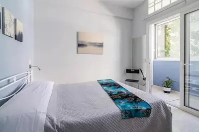 a white bedroom with a bed and a window at Lovely apartment in the center of Athens. in Athens