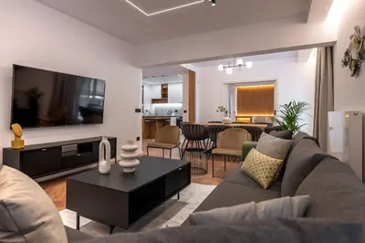 a living room with a couch and a tv at Phaedrus Living Luxury Penthouse Ploutarchou in Athens