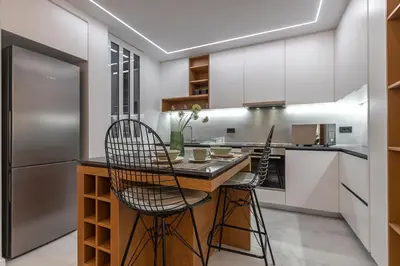 a kitchen with a counter and two chairs at a bar at Phaedrus Living Luxury Penthouse Ploutarchou in Athens