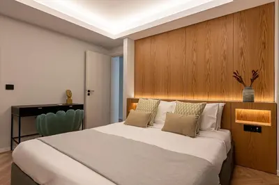 a bedroom with a large bed with a wooden wall at Phaedrus Living Luxury Penthouse Ploutarchou in Athens