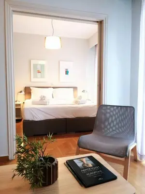 a bedroom with a bed and a chair and a table at Stylish apartment in Acropolis in Athens