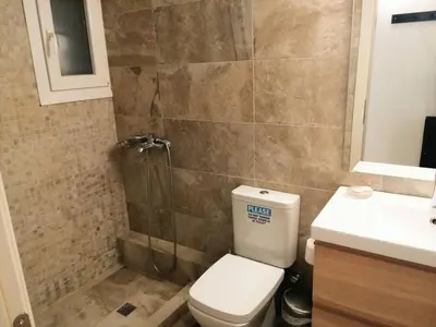 a bathroom with a shower and a toilet and a sink at Stylish apartment in Acropolis in Athens