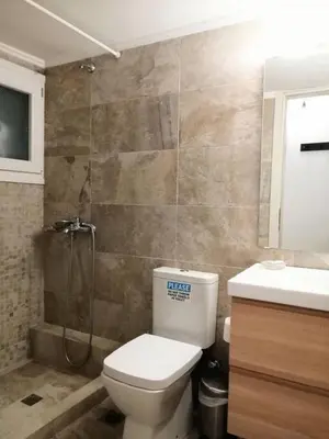 a bathroom with a toilet and a shower and a sink at Stylish apartment in Acropolis in Athens