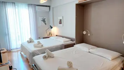 a hotel room with two beds with towels on them at Stylish apartment in Acropolis in Athens