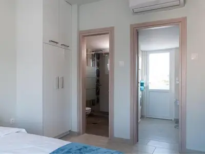 a bedroom with a door leading to a bathroom at Konstantinou Apartment - smart & roof top terrace in Athens
