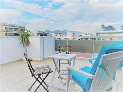 a patio with chairs and a table on a roof at Konstantinou Apartment - smart & roof top terrace in Athens