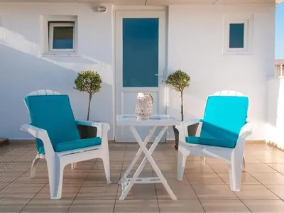 two blue chairs and a white table and a table at Konstantinou Apartment - smart & roof top terrace in Athens