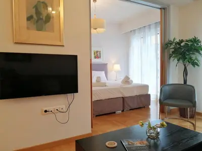 a living room with a bed and a flat screen tv at Elegant apartment in Acropolis in Athens