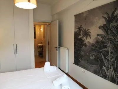 a bedroom with a large painting on the wall at Elegant apartment in Acropolis in Athens
