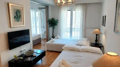 a living room with two beds and a flat screen tv at Elegant apartment in Acropolis in Athens