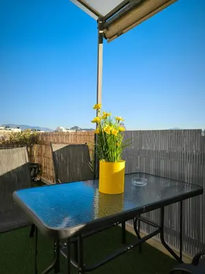 a table on a balcony with a yellow pot on it at Group & family penthouse 300m from Agios Ioannis subway,metro station! in Athens