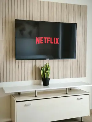 a flat screen tv on a wall above a white cabinet at Group & family penthouse 300m from Agios Ioannis subway,metro station! in Athens
