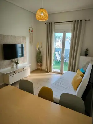 a room with a bed and a table and a television at Group & family penthouse 300m from Agios Ioannis subway,metro station! in Athens