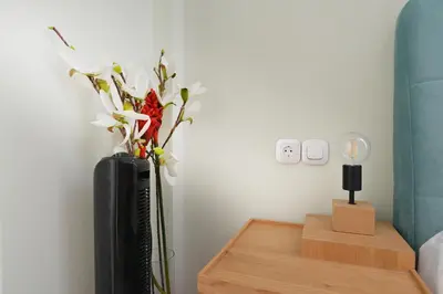 a vase with flowers on a table in a room at Colorful Apt. Near Nea Smirni Square in Athens