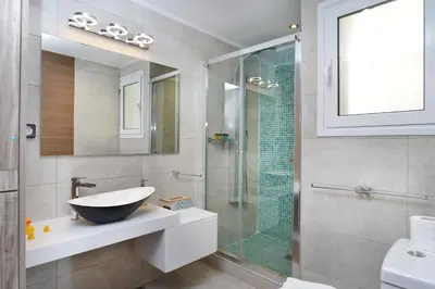 a bathroom with a sink and a glass shower at Colorful Apt. Near Nea Smirni Square in Athens