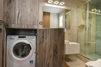 a washing machine in a bathroom with a shower at Colorful Apt. Near Nea Smirni Square in Athens