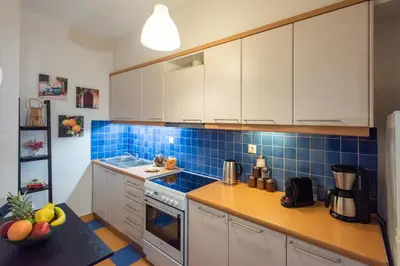 a kitchen with white cabinets and blue tiles at Blue Ark Acropolis Spirit in Athens