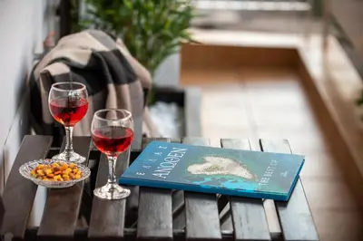 a book and two glasses of wine on a table at Blue Ark Acropolis Spirit in Athens